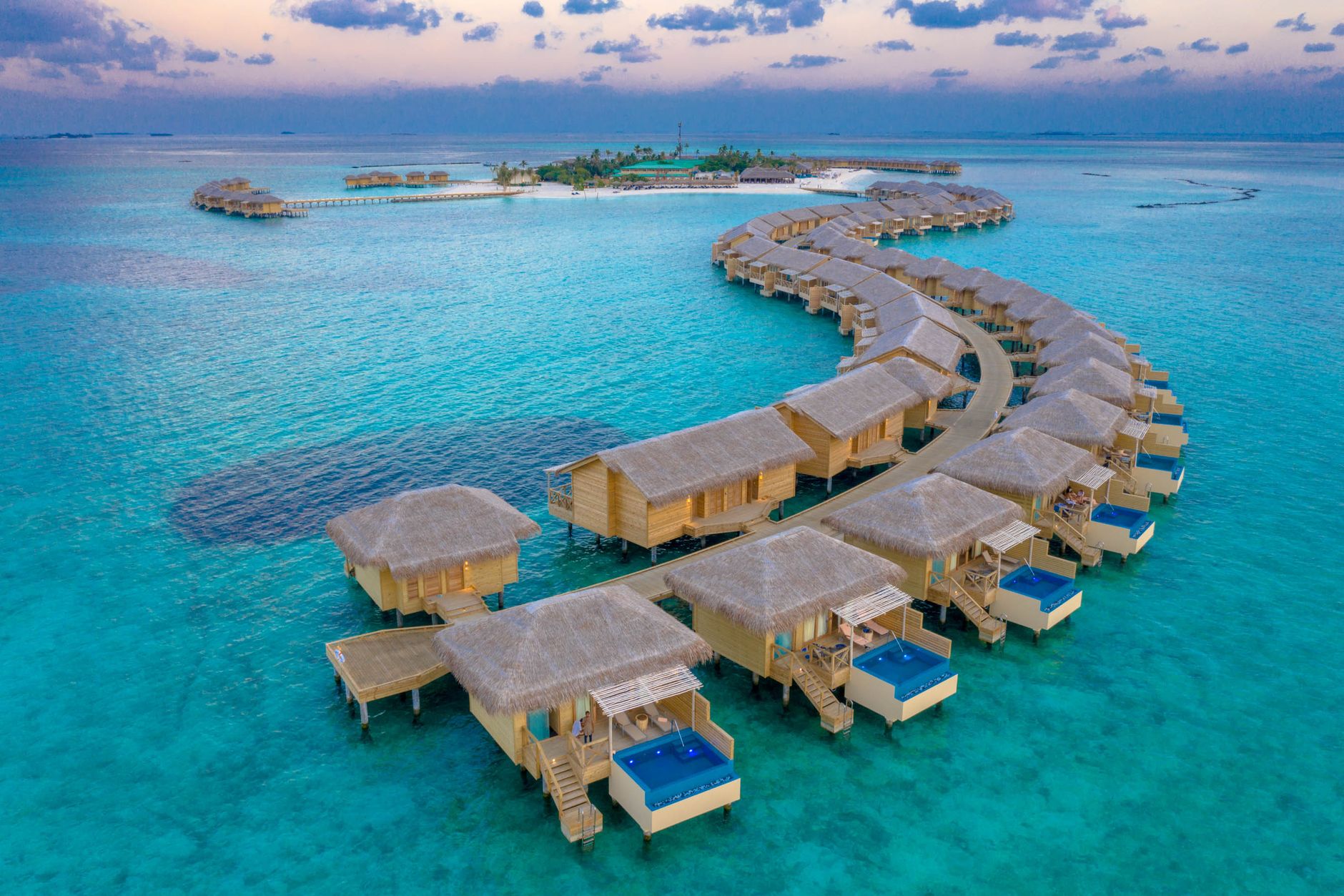 Ultra-luxury resort overwater villas and pool representing Four Seasons and Marriott STARS bookings