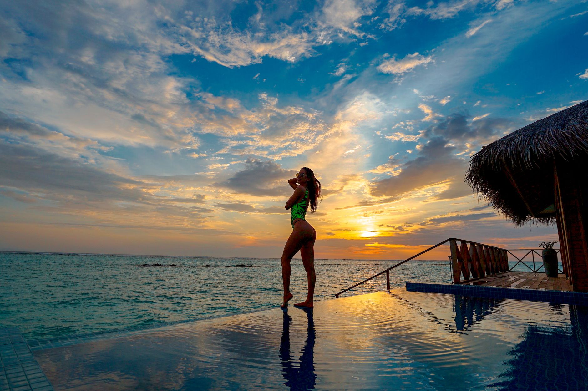 Luxury travel advisor filming social media reel on smartphone overlooking infinity pool at luxury resort