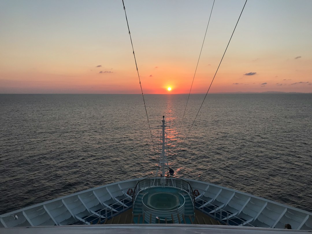 Luxury cruise ship top pool deck overlooking sunset ocean view