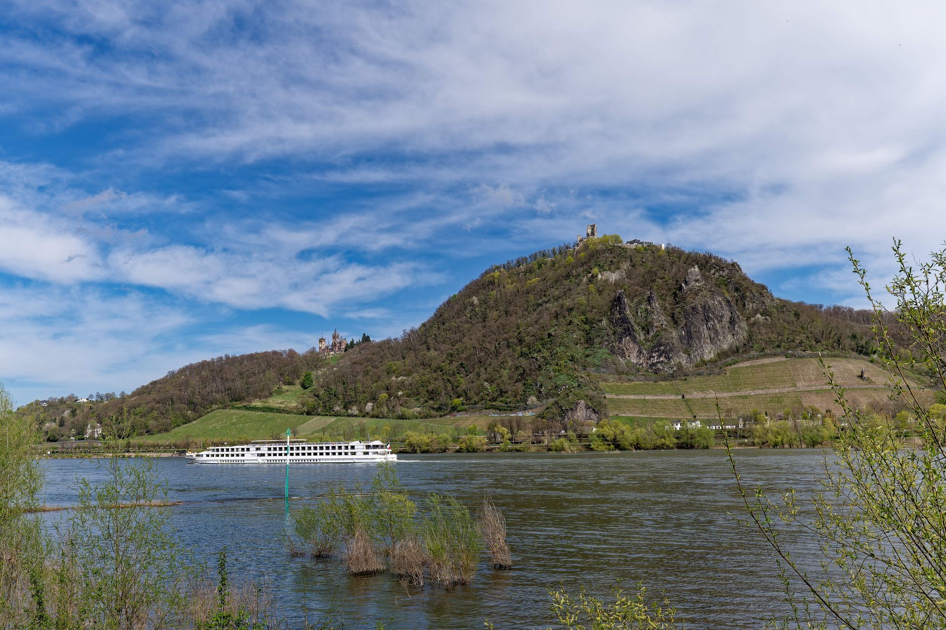 Luxury European river cruise ship sailing through scenic vineyard valley