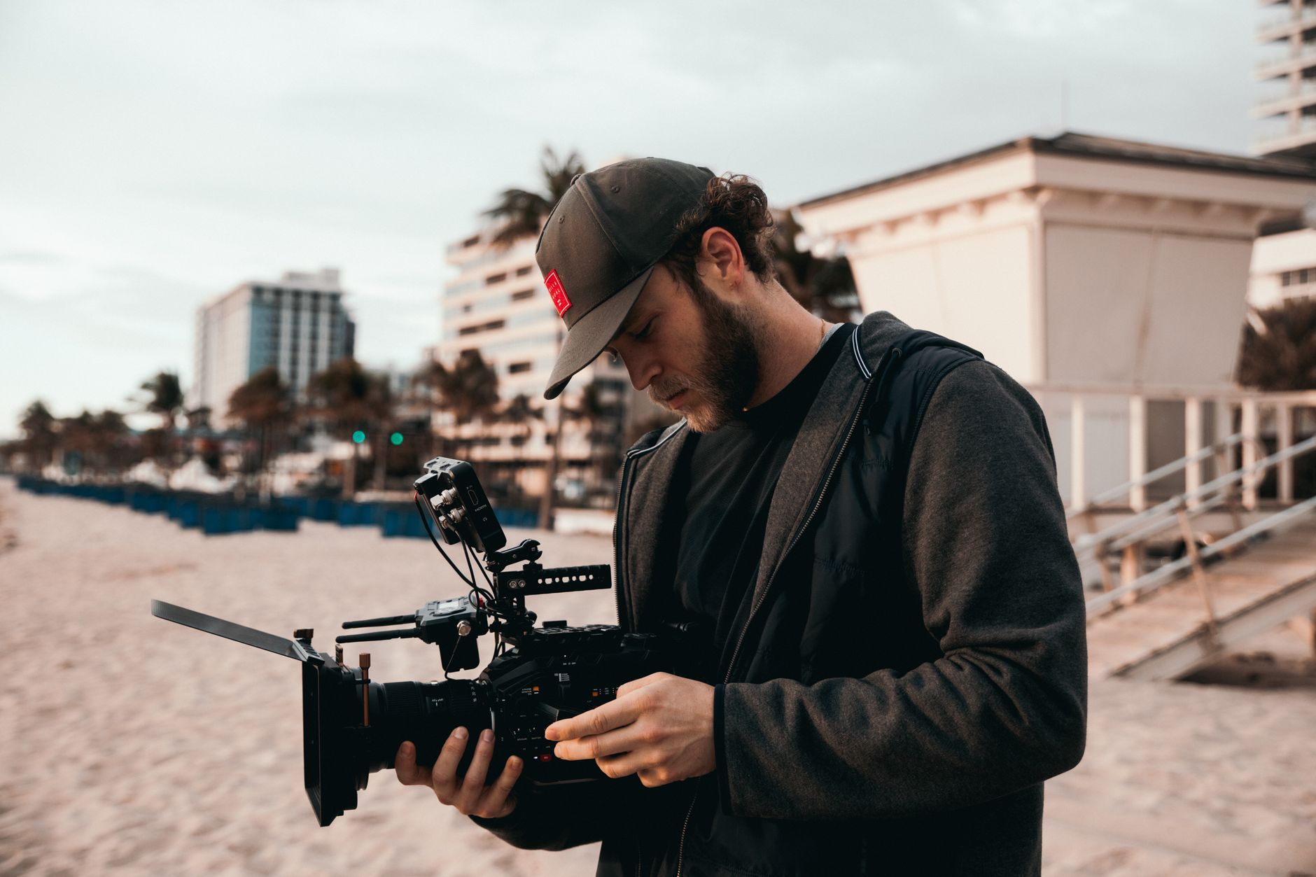 Travel advisor walking through luxury resort with palm trees filming smartphone video